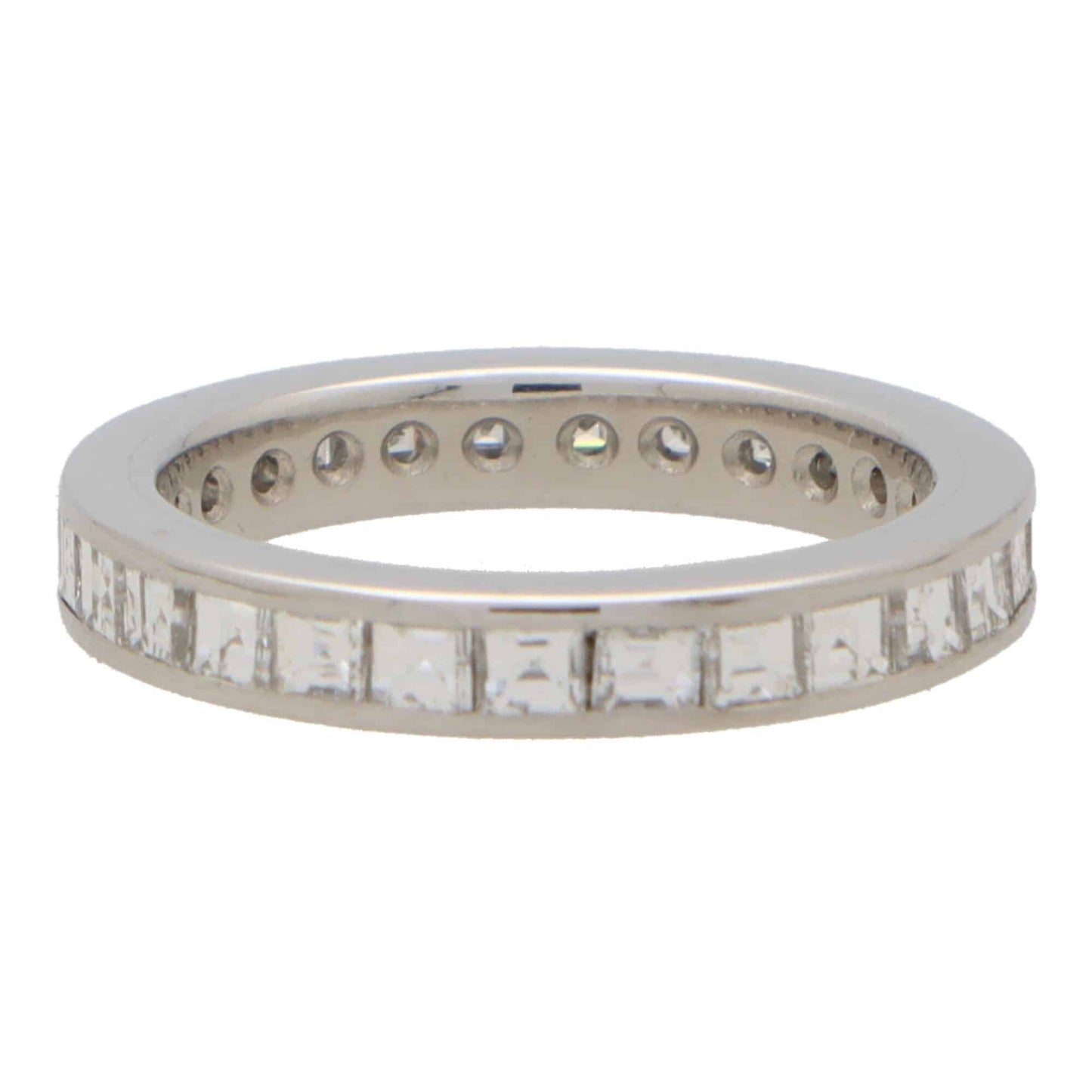 A square shaped diamond and platinum eternity ring, on a white background