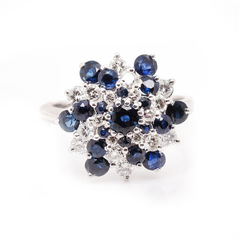 A sapphire and diamond swirl cluster ring in white gold