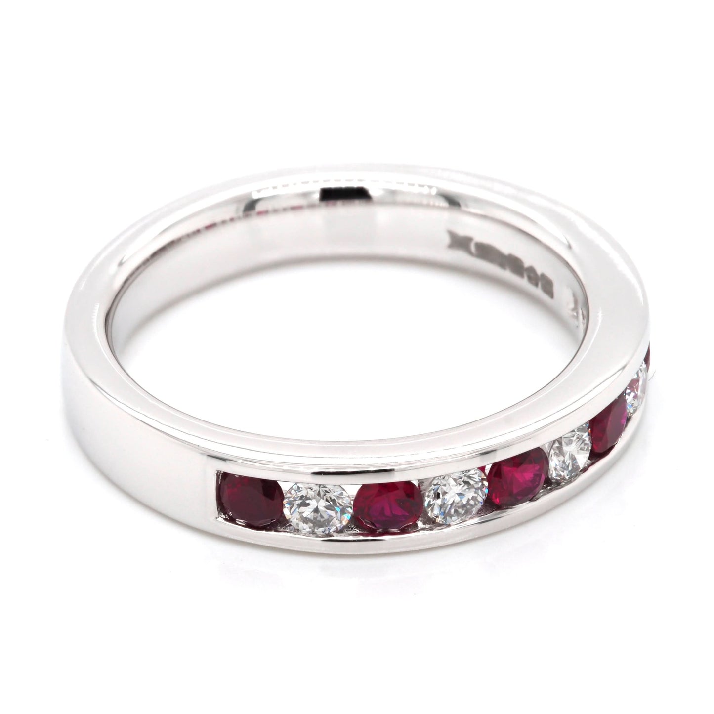 A platinum channel set half eternity ring with rubies and diamonds