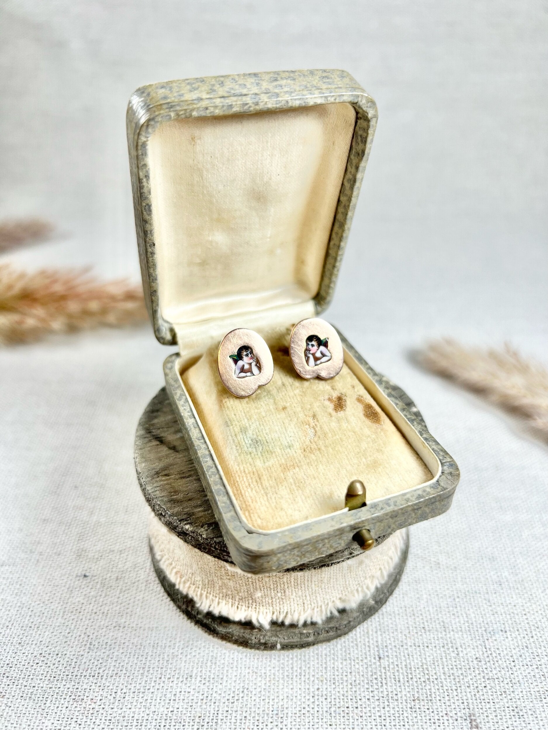 A pair of art palette shaped gold earrings with enamelled cherubs, in a box