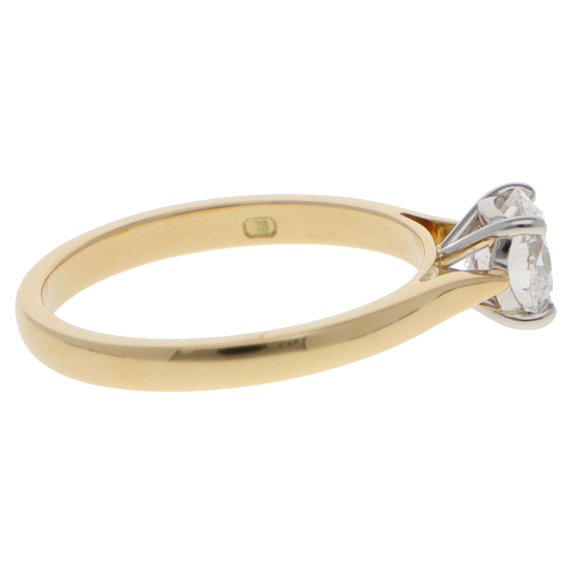 A yellow gold and platinum solitaire brilliant cut diamond ring, on a white background