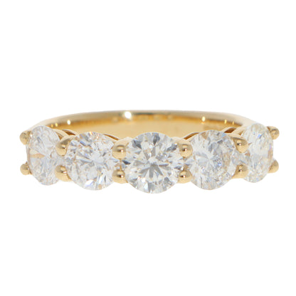 A five stone round brilliant cut diamond ring in yellow gold, on a white background