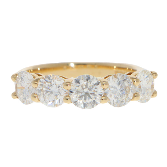 A five stone round brilliant cut diamond ring in yellow gold, on a white background
