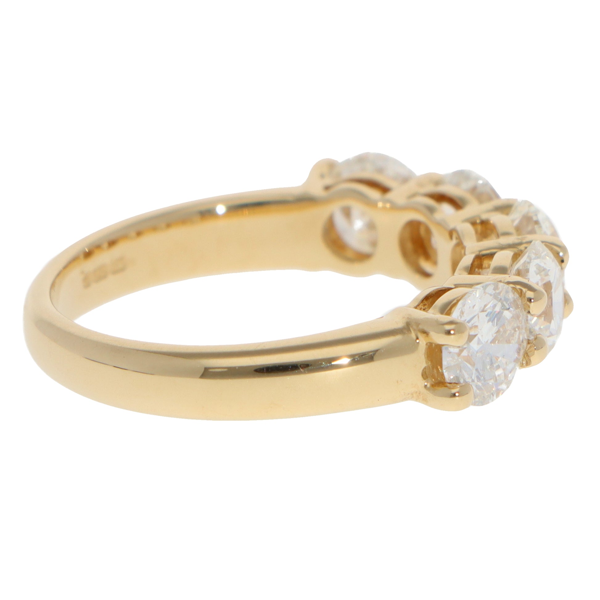 A five stone round brilliant cut diamond ring in yellow gold, on a white background