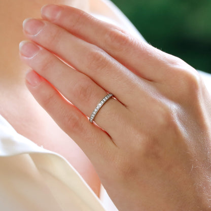 A platinum diamond full eternity band ring modelled on the ring finger of a woman