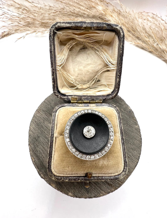 A circular black onyx and diamond cluster ring, in an antique ring box