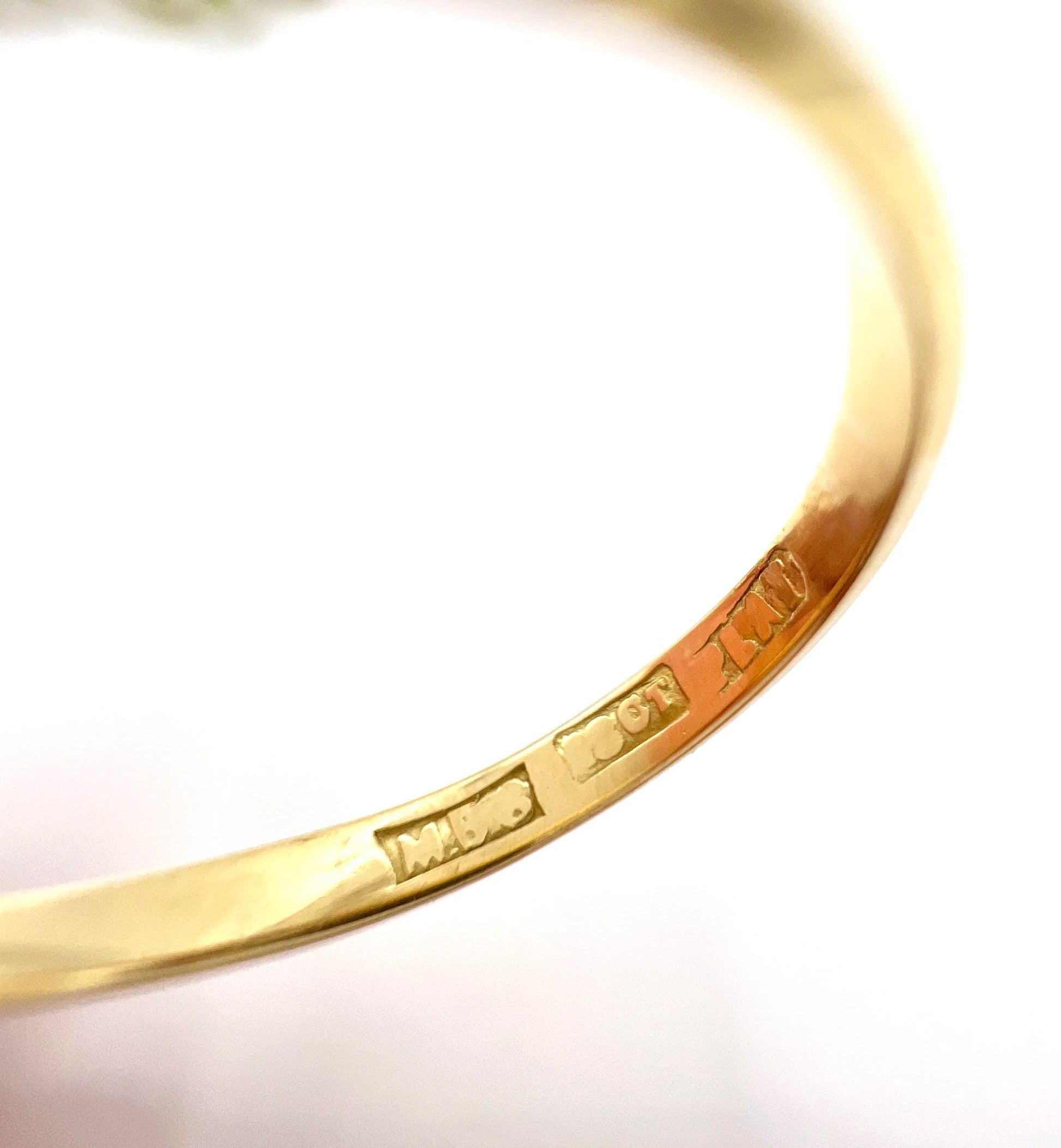 Close-up of 18CT PLAT and maker's mark stamps inside a yellow gold ring shank