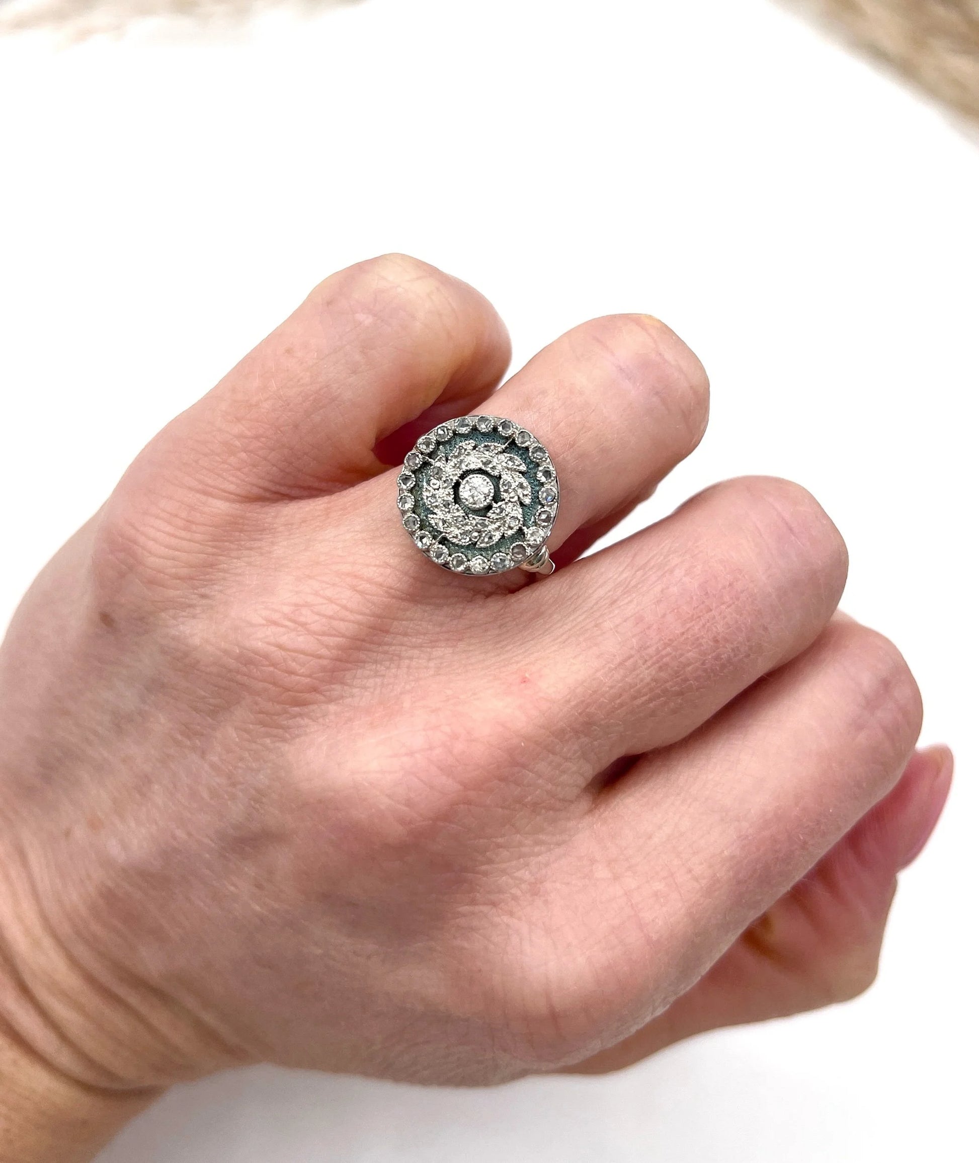 A diamond and dark blue enamel fancy cluster ring in white gold, modelled on a hand