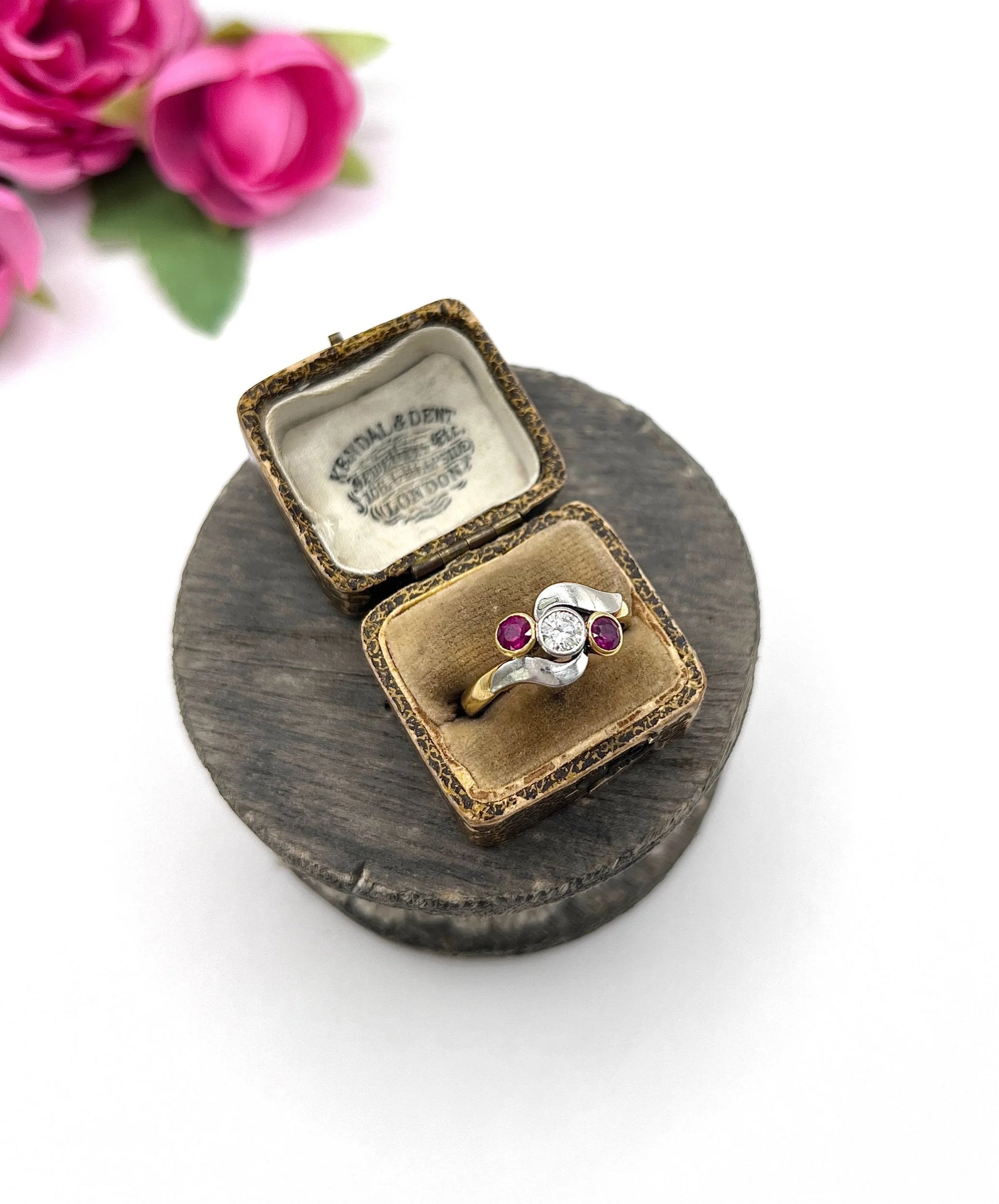 A three stone ruby and diamond crossover ring in platinum and yellow gold, in a ring box