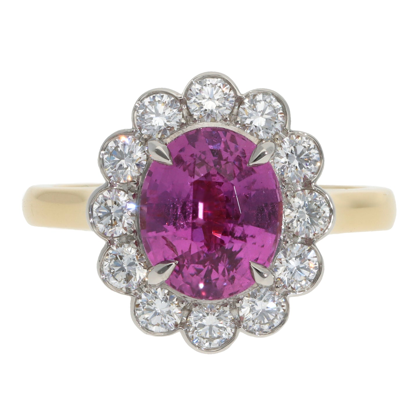 A pink sapphire and diamond oval cluster ring in yellow gold and platinum, on a white background