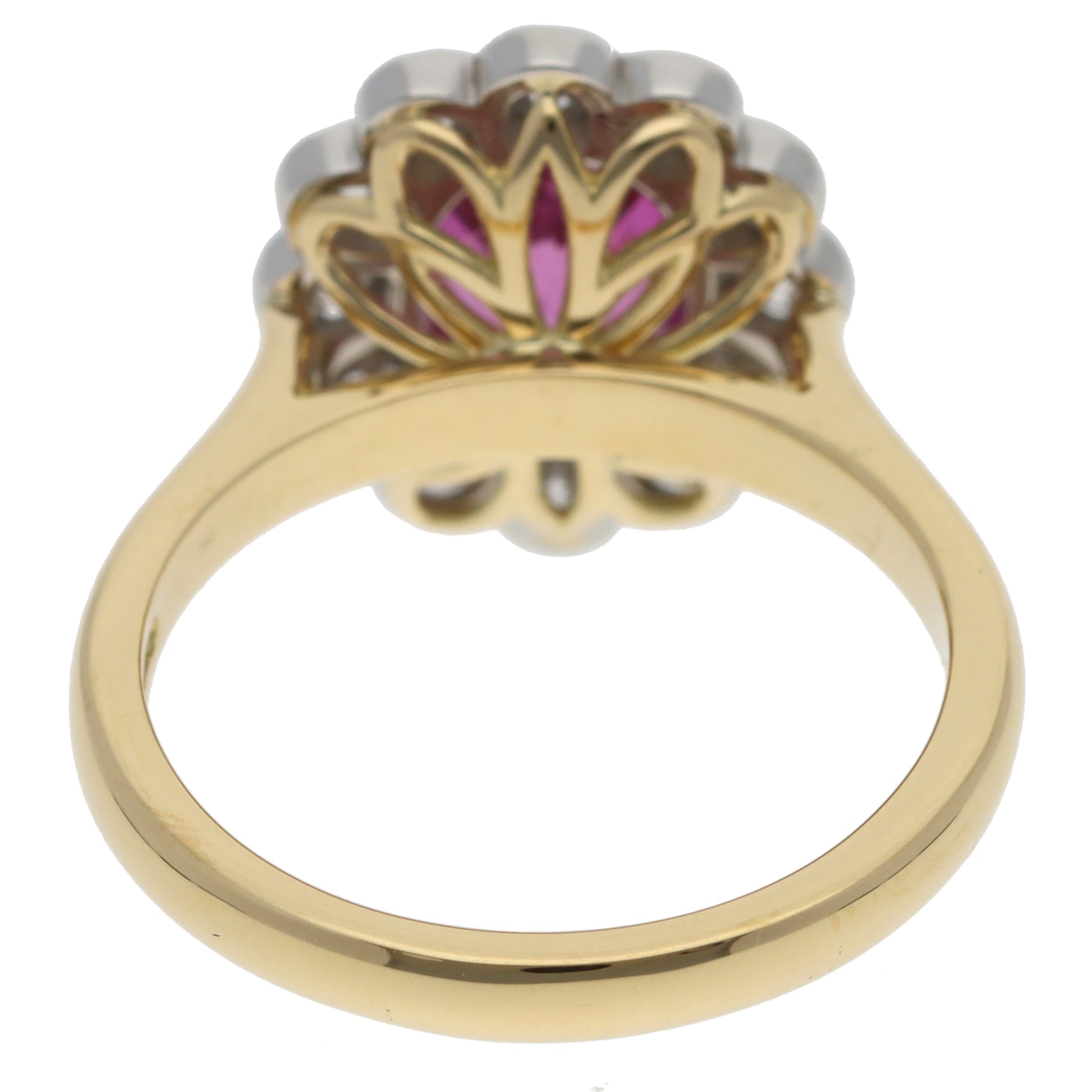 A pink sapphire and diamond oval cluster ring in yellow gold and platinum, on a white background