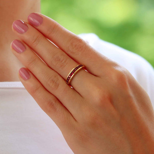 Ruby half eternity ring set in 18 carat yellow gold.