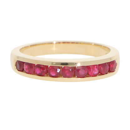 A yellow gold half eternity band with round rubies, on a white background
