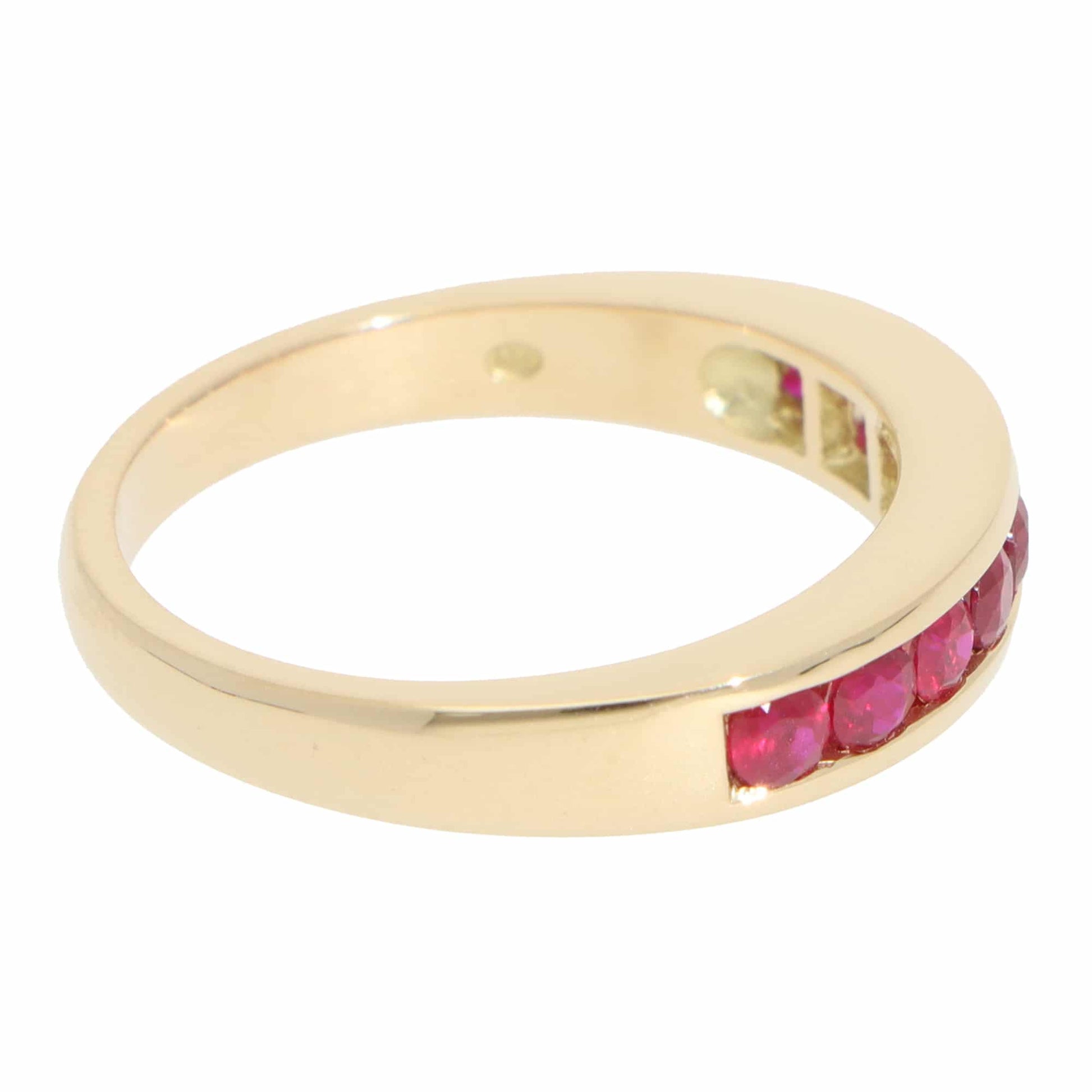 A yellow gold half eternity band with round rubies, on a white background
