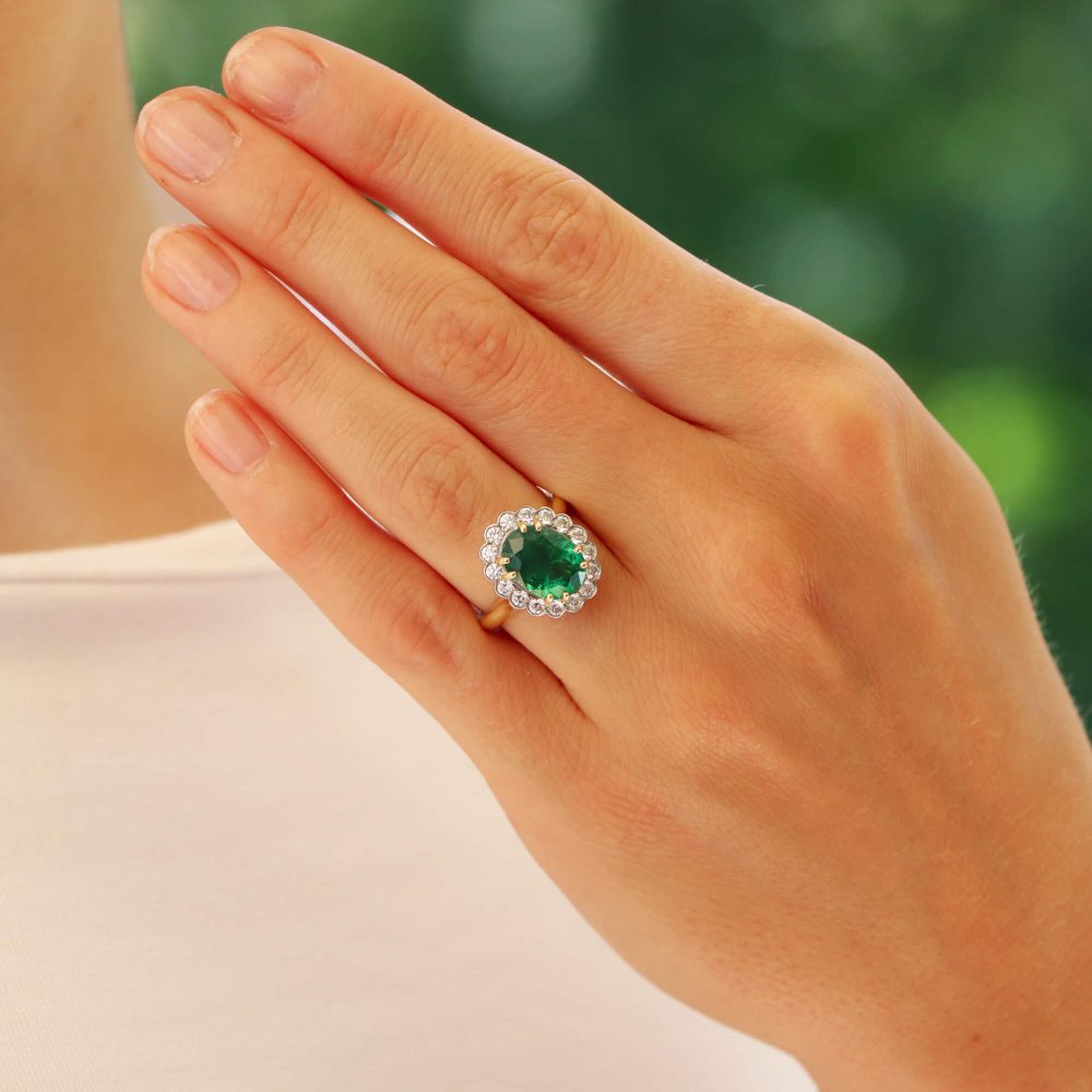 Emerald and diamond cluster ring in gold and platinum.