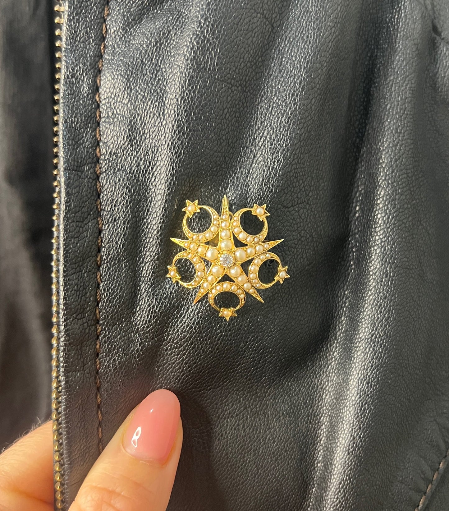 A yellow gold star and crescent brooch/pendant set with a diamond and pearls, modelled on a black jacket