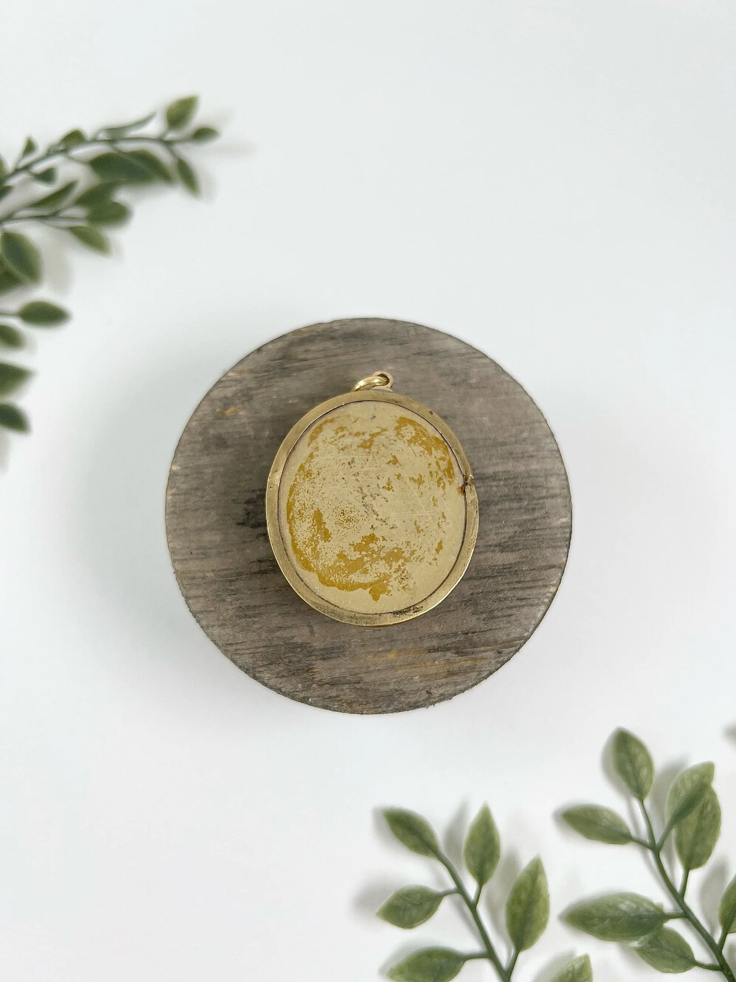 An oval cherub lava cameo pendant in yellow gold