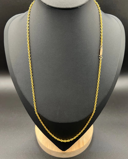A yellow gold trace link chain necklace, modelled on a black jewellery bust