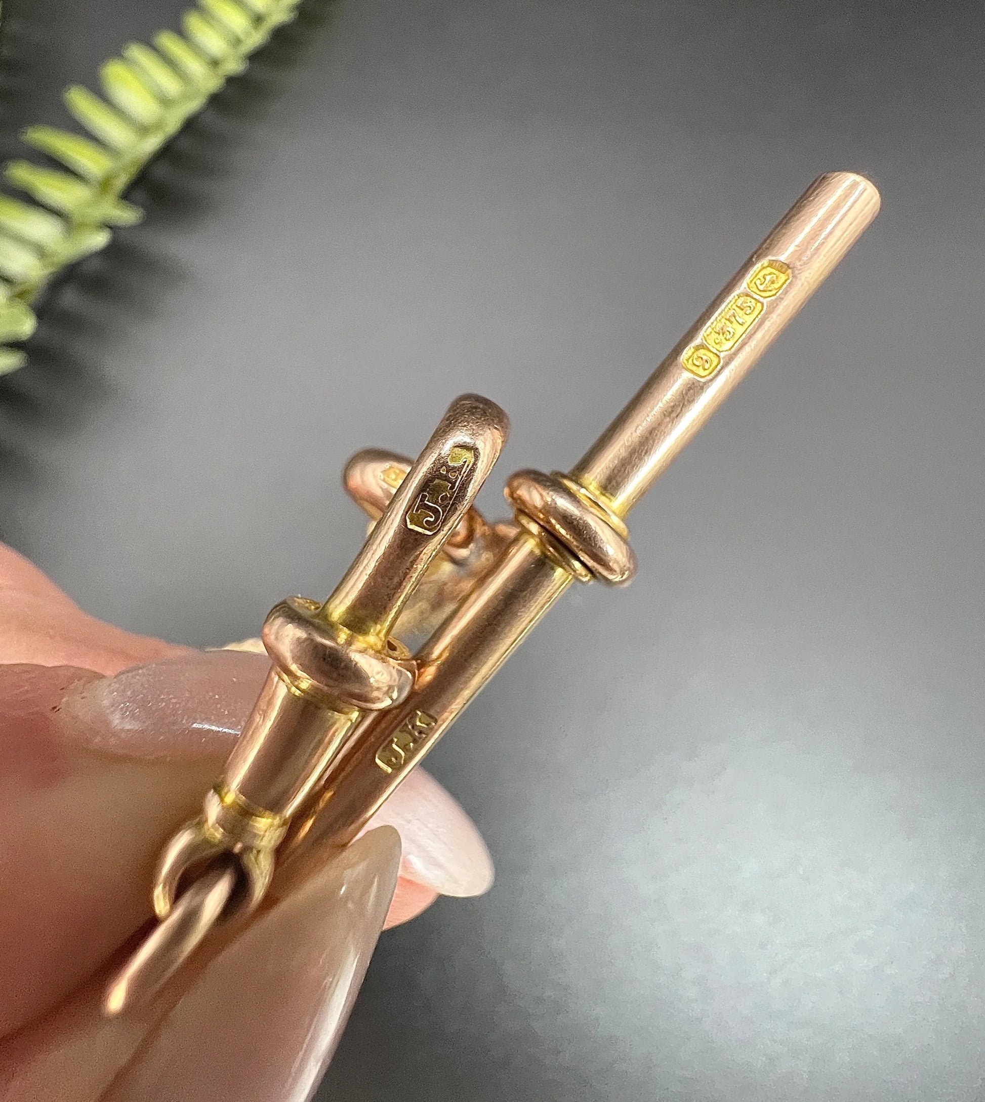 Close-ups of a gold T-bar and swivel dog clip