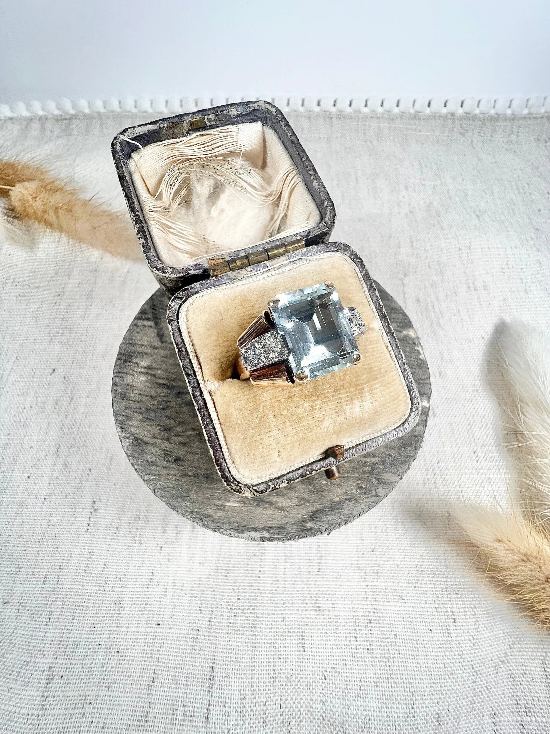 An aquamarine and diamond cocktail ring in gold, in an antique ring box