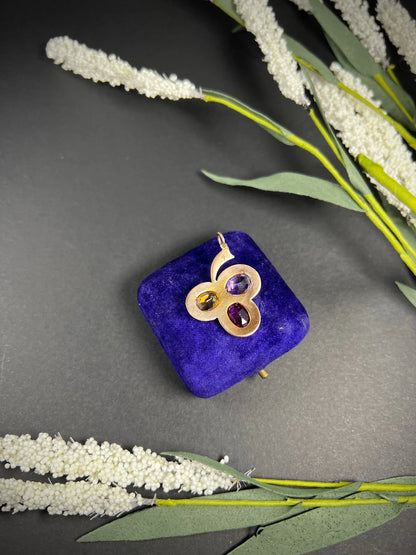 A yellow gold clover pendant with amethyst, citrine, garnet and seed pearls