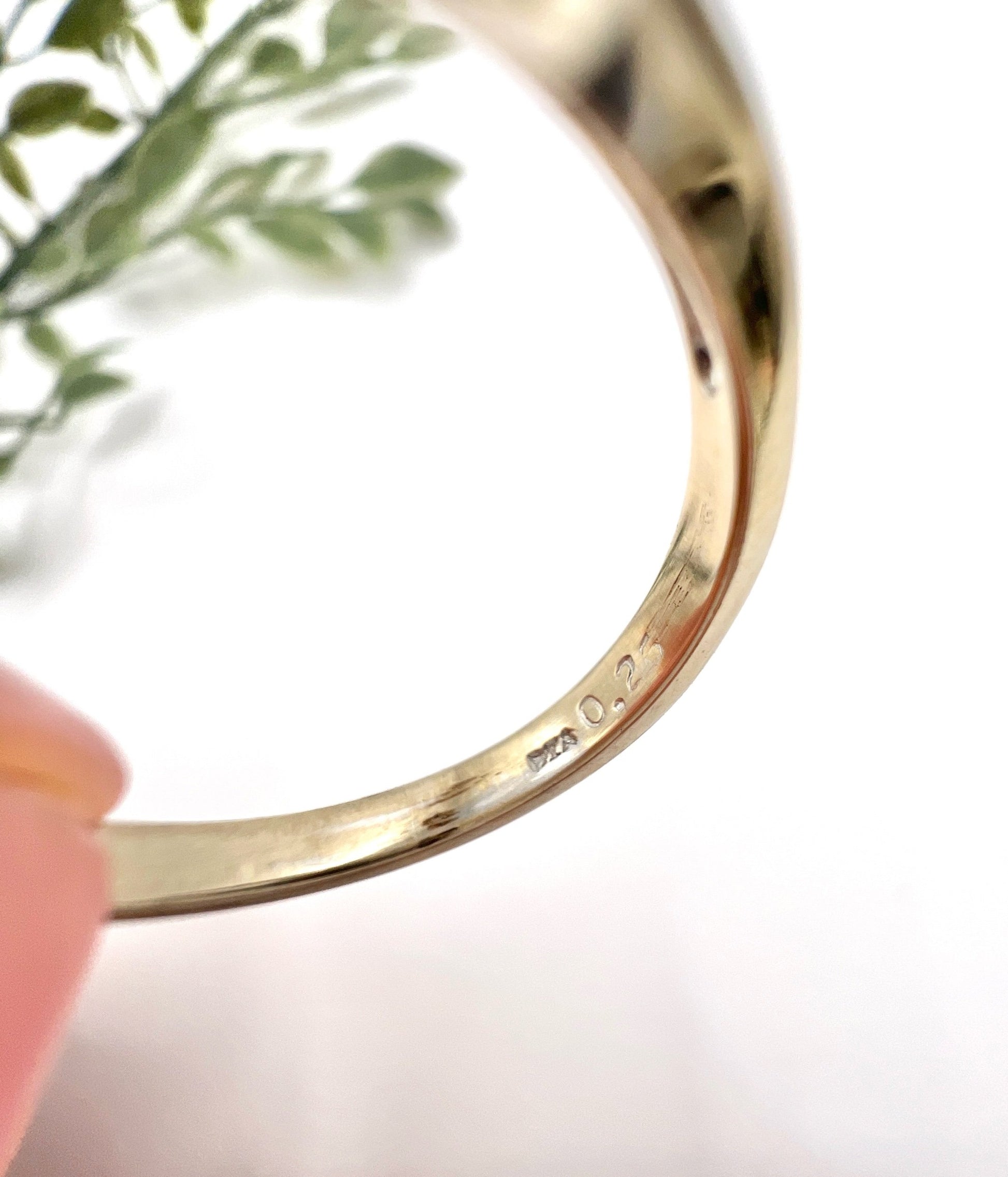 Close-up of stamps inside a white gold ring shank