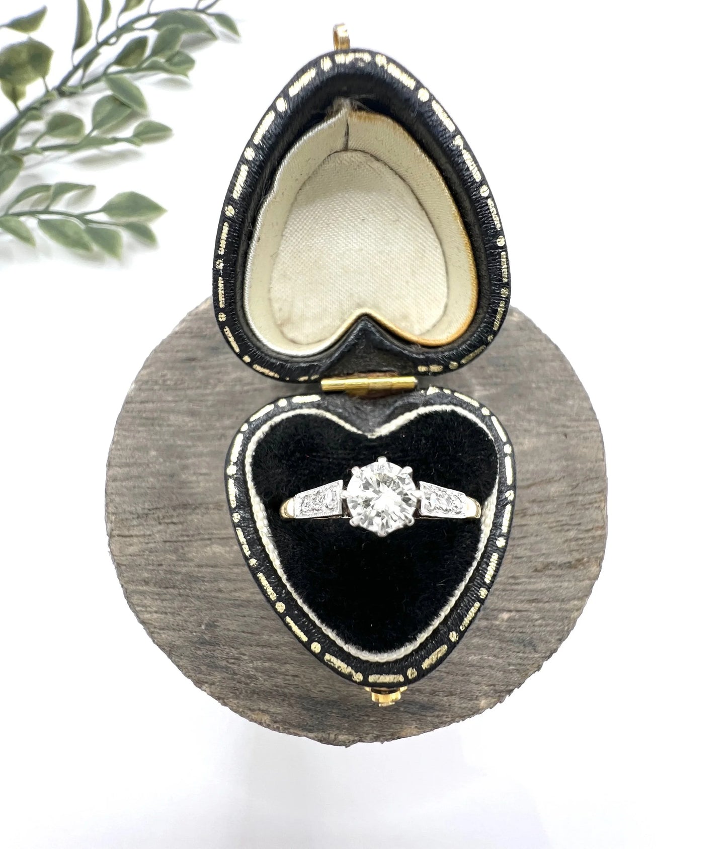 A diamond engagement style ring in yellow gold and platinum, in a heart-shaped ring box