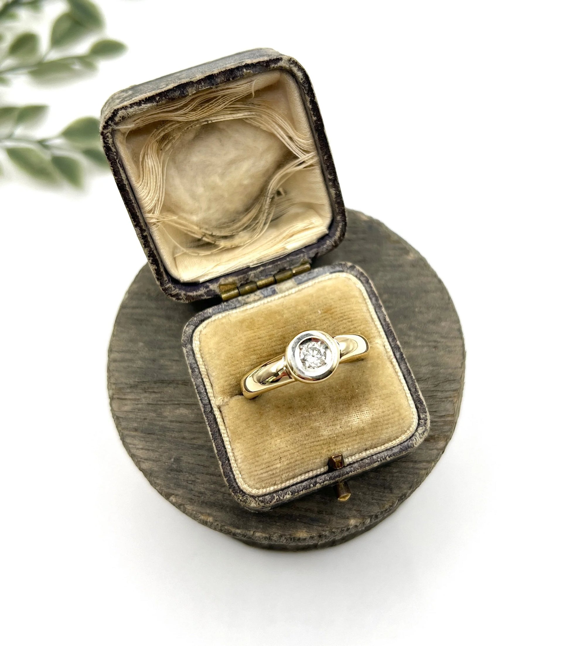 A single stone brilliant cut diamond ring bezel set in yellow gold, in a ring box