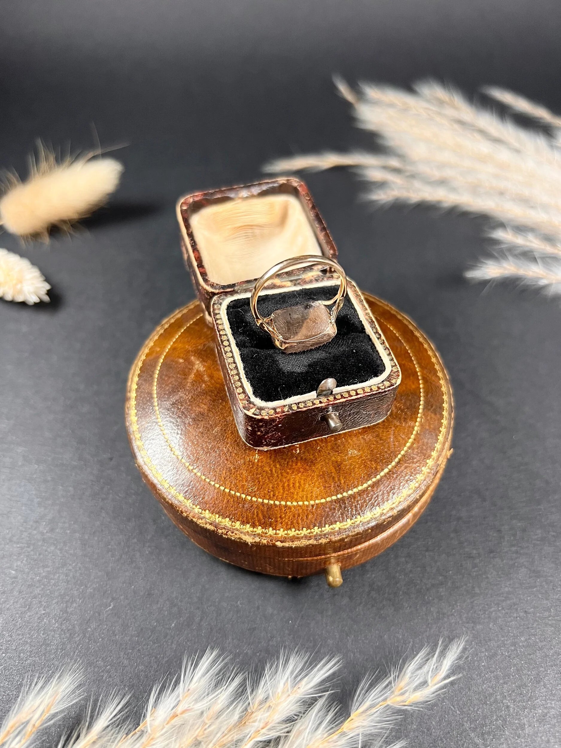 A cabochon amethyst and pearl halo cluster ring in gold, in a ring box