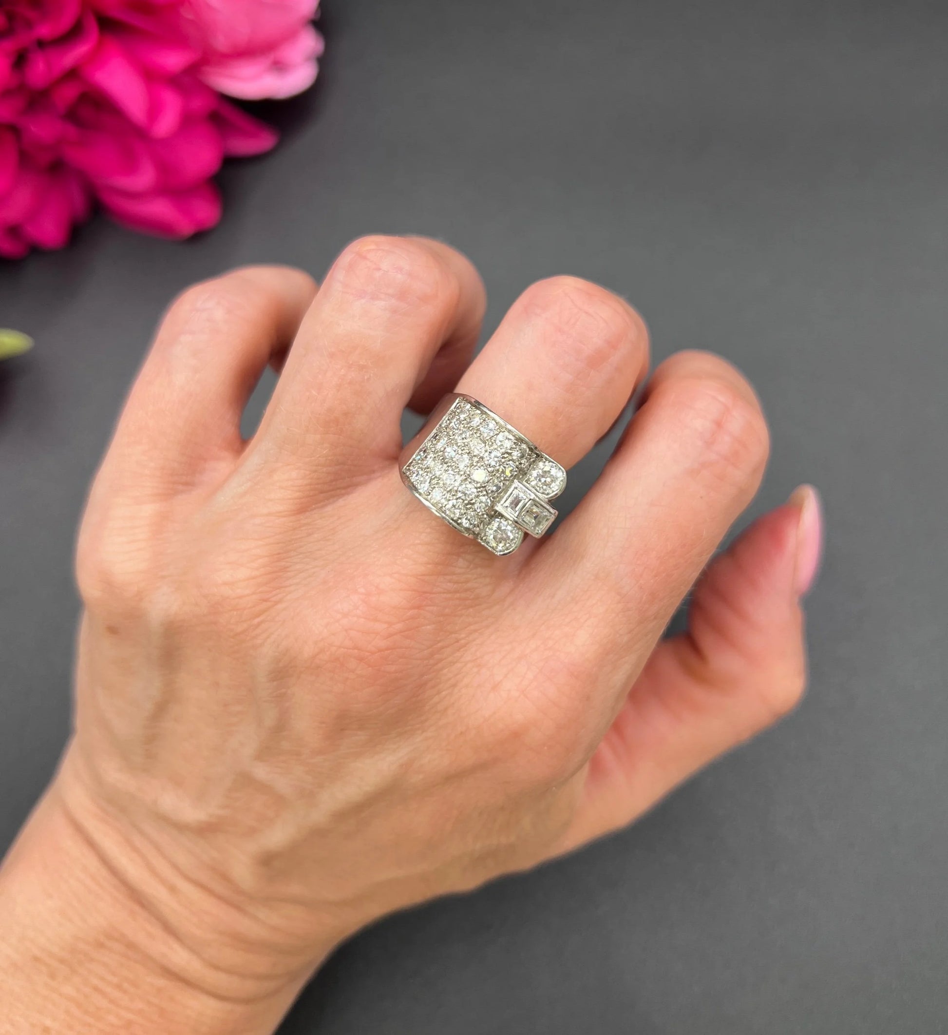 A round diamond tank style cocktail ring in platinum, modelled on a hand