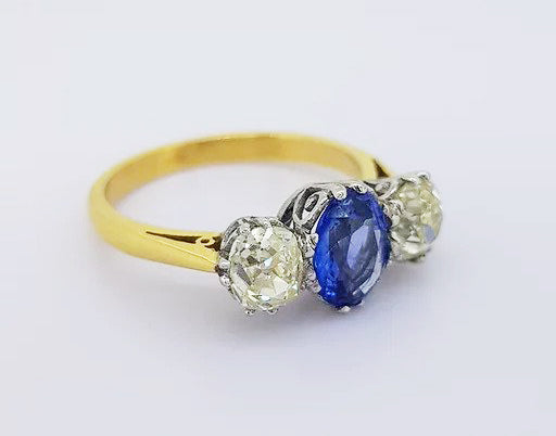 1.20ct Sapphire and 1.35ct Diamond Three Stone Ring; classic trilogy ring, central oval sapphire flanked by two round-cut diamonds. Mounted in 18ct white gold settings on an 18ct yellow gold shank.