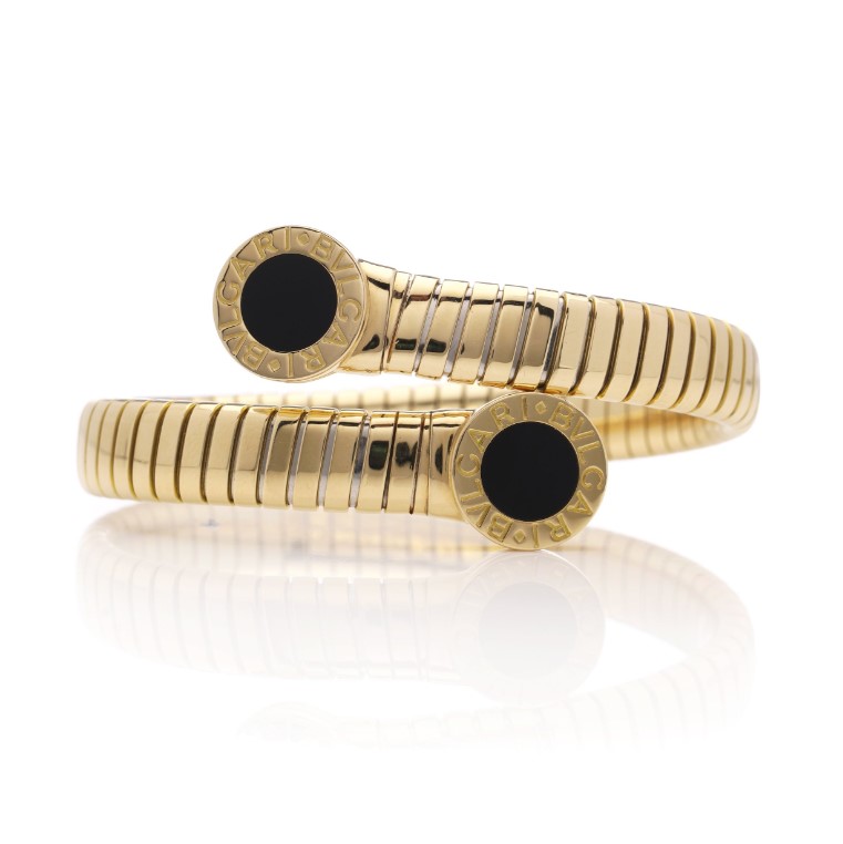Vintage Bvlgari 18ct Yellow Gold and Onyx Tubogas Bangle Bracelet, 18ct yellow gold tubogas flexible sprung cuff made of coiled gas pipe links with terminals of circular onyx plaques encased in a polished surround engraved with the BVLGARI BVLGARI motif. Made in Italy, Alexandria, Circa 1990s