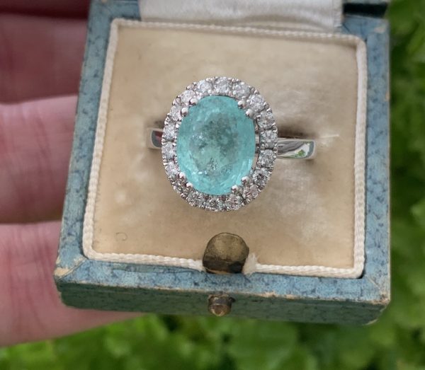 Paribia Tourmaline and Diamond Cluster Ring in 18ct White Gold; 3.73 carat oval faceted aqua/greenish-blue Paribia tourmaline surrounded by diamonds