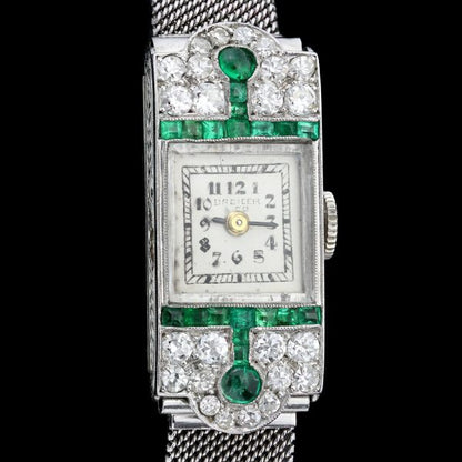 Art Deco Diamond, Emerald and Platinum Manual Cocktail Watch by Drecier and Co; set with 0.64cts emeralds and 0.90cts old-cut diamonds, Circa 1920s