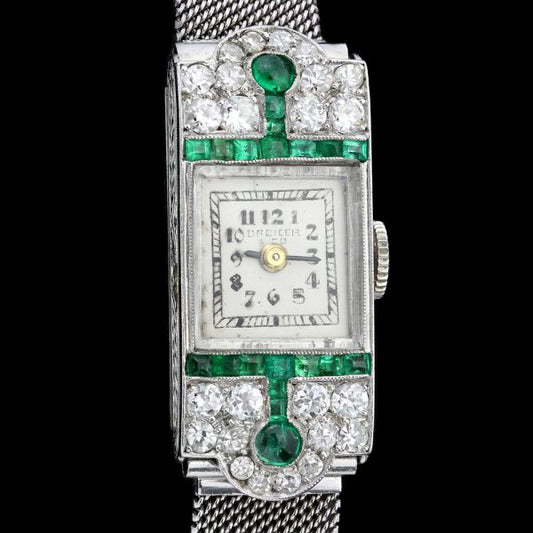 Art Deco Diamond, Emerald and Platinum Manual Cocktail Watch by Drecier and Co; set with 0.64cts emeralds and 0.90cts old-cut diamonds, Circa 1920s