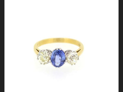 Classic sapphire and diamond trilogy ring.Central oval cut Sapphire 1.20 carats flanked by two round cut diamonds totaling 1.35 carats