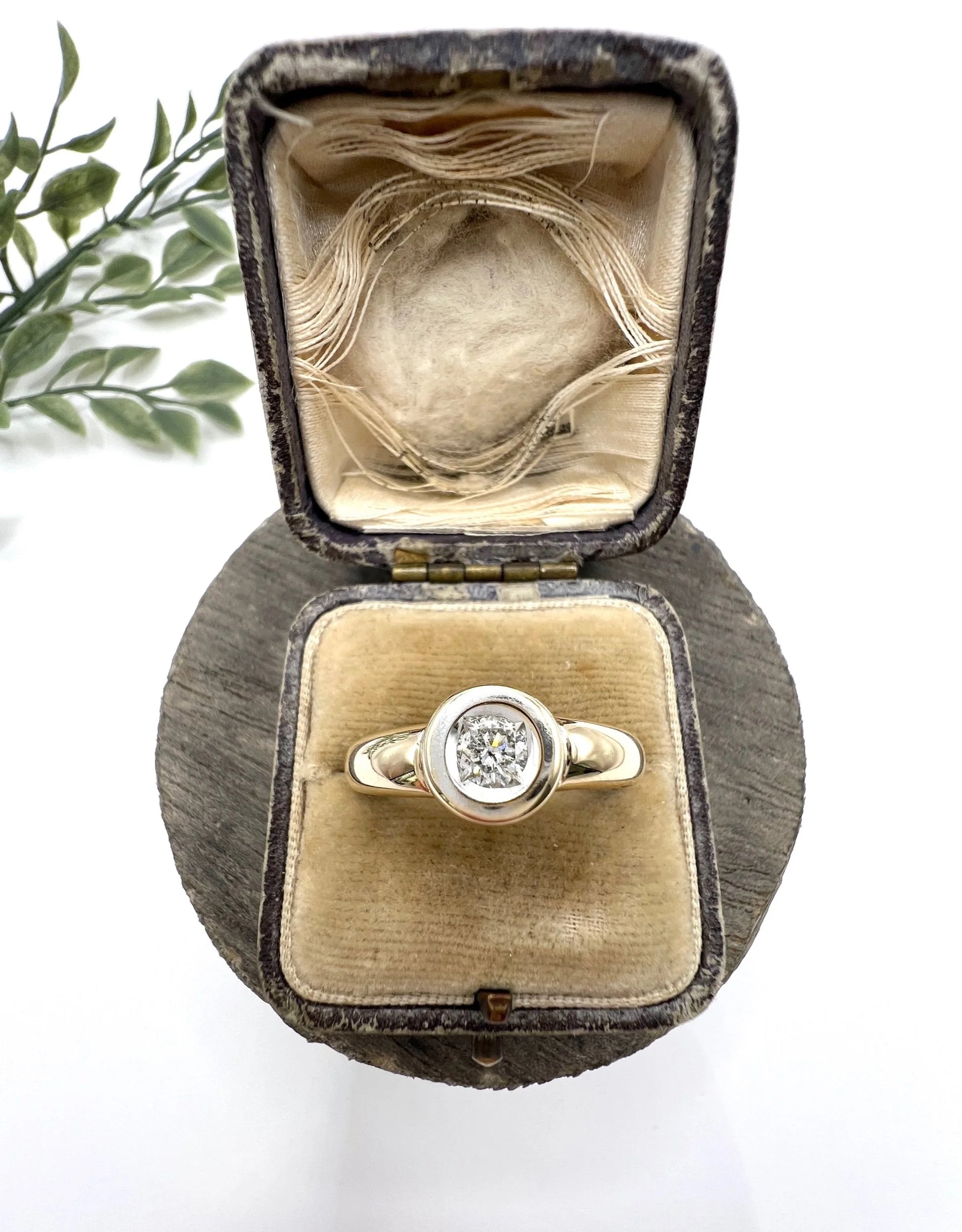 A single stone brilliant cut diamond ring bezel set in yellow gold, in a ring box