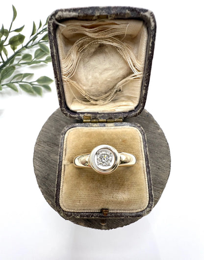 A single stone brilliant cut diamond ring bezel set in yellow gold, in a ring box
