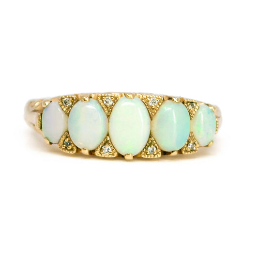 An opal and diamond graduating ring in yellow gold