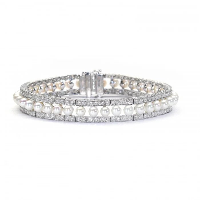Modern Pearl and Diamond Bracelet in Platinum, row of forty-one cultured pearls flanked either side by 3.81cts round brilliant-cut diamonds in paired grain settings