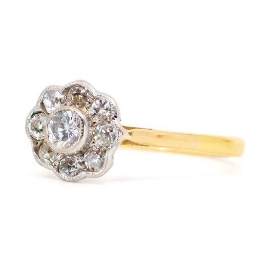 A yellow and white gold diamond cluster ring