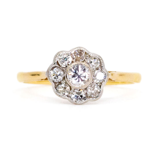 A yellow and white gold diamond cluster ring