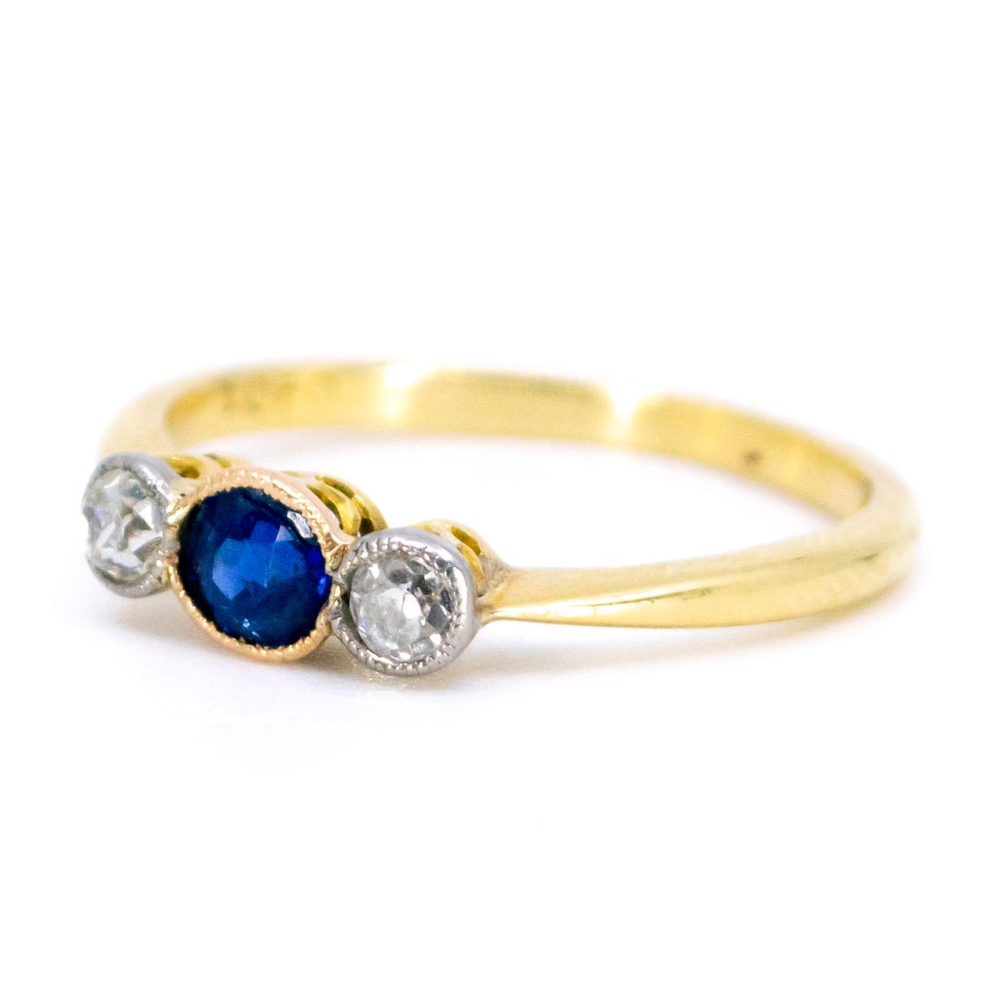 A three stone sapphire and diamond ring in yellow and white gold
