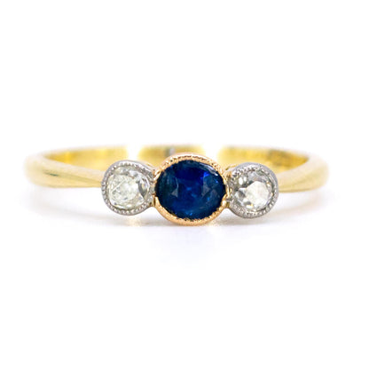 A three stone sapphire and diamond ring in yellow and white gold
