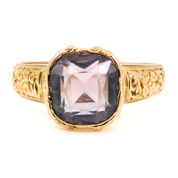 A solitaire amethyst ring in yellow gold with chased shoulders