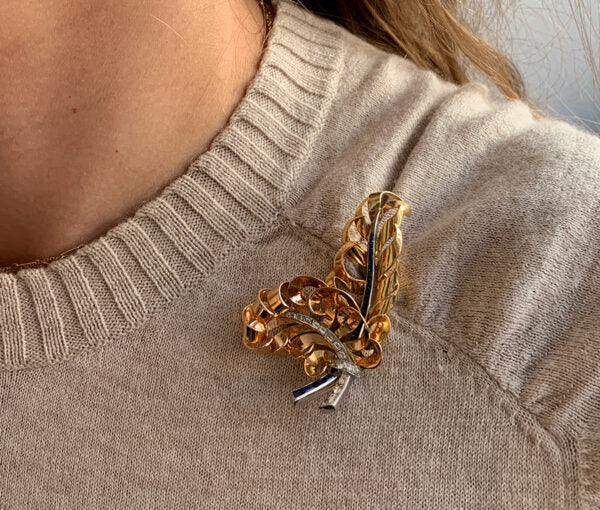 Vintage French Retro 18ct Gold, Diamond and Sapphire Feather Brooch; 18ct rosé and yellow gold feathers set with calibré diamonds and sapphires, with diamond set platinum ribbon.