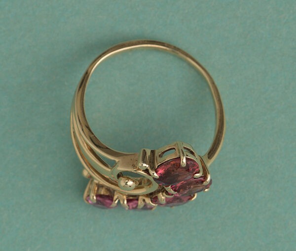 Vintage Pink Tourmaline and 18ct Yellow Gold Flower Ring; set with five oval faceted pink tourmalines beautifully graduating in size and colour, Circa 1950