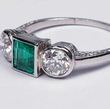 Princess Cut Colombian Emerald and Diamond Three Stone Ring; central 0.50 carats modified square-cut emerald of intense colour set in-between two old European transitional cut diamonds totalling 0.66 carats, in platinum