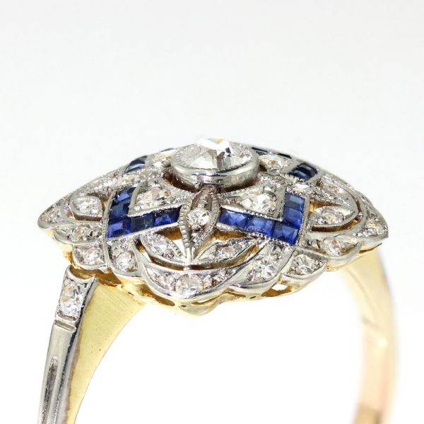 Art Deco Sapphire and Old Cut Diamond Cluster Dress Ring; pierced platinum mount set with 0.50cts old cut diamonds and 0.24cts princess-cut sapphires, with later added 18ct gold shank