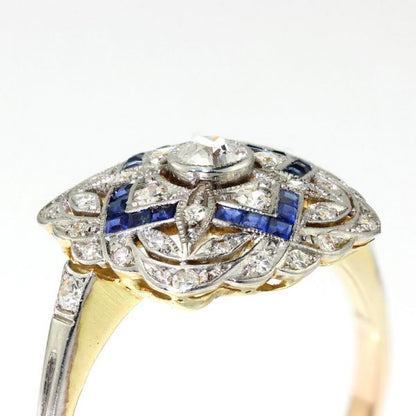 Art Deco Sapphire and Old Cut Diamond Cluster Dress Ring; pierced platinum mount set with 0.50cts old cut diamonds and 0.24cts princess-cut sapphires, with later added 18ct gold shank
